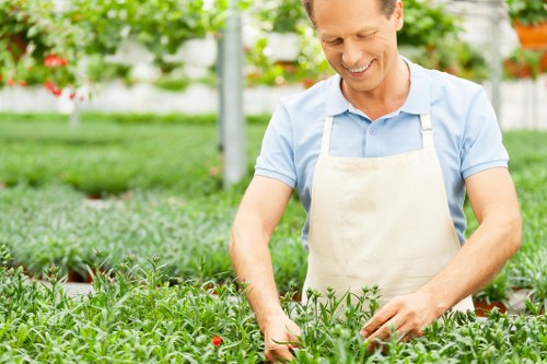 Gardening operative wearing PPE and using tools safely